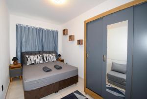 ein Schlafzimmer mit einem Bett und eine Tür mit einem Spiegel in der Unterkunft Apartamento moderno numa ótima localização! in São José + 19 Fotos