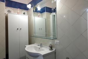 a white bathroom with a sink and a mirror at Memoir Appartamento Lecce in Lecce
