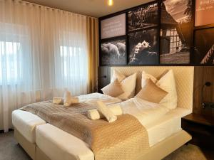 a bedroom with a large white bed with two pillows at Hotel Da Toni in Neuenkirchen