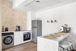 a kitchen with a washer and dryer next to a refrigerator at Chic Studio with a Bath Tub, Pool & Gym near Golf Club in Dubai