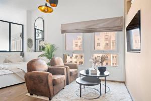a living room with two chairs and a table at Chic Studio with a Bath Tub, Pool & Gym near Golf Club in Dubai