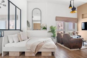 a living room with a bed and a chair at Chic Studio with a Bath Tub, Pool & Gym near Golf Club in Dubai