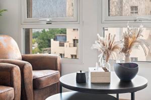a living room with a table and a chair and a couch at Chic Studio with a Bath Tub, Pool & Gym near Golf Club in Dubai