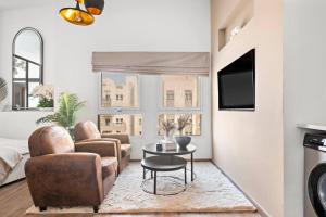 a living room with a couch and chairs and a table at Chic Studio with a Bath Tub, Pool & Gym near Golf Club in Dubai