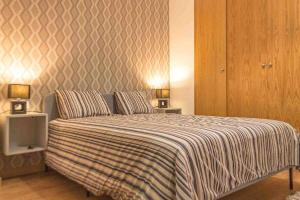1 dormitorio con 1 cama con manta a rayas en Apartment Central House, en Castellón de la Plana