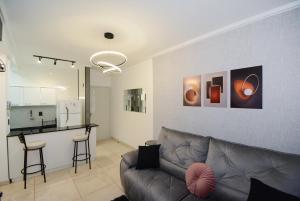 ein Wohnzimmer mit Couch und Küche in der Unterkunft Apartamento moderno numa ótima localização! in São José
