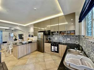 a large kitchen with a refrigerator and a sink at Amani Luxury Apartments in Diani Beach