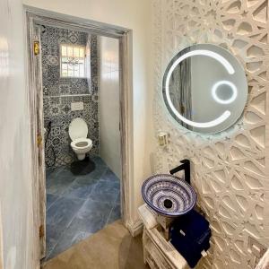 a bathroom with a toilet and a mirror on the wall at Amani Luxury Apartments in Diani Beach