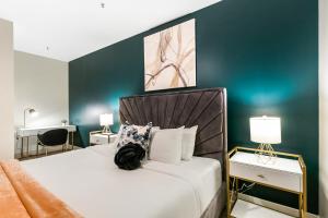 a bedroom with a bed and two tables with lamps at Chic 4Bed Oasis Steps from French Quarter Magic! in New Orleans