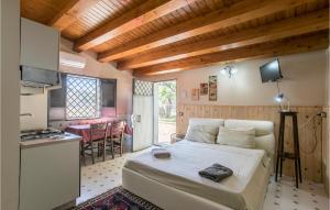 ein Schlafzimmer mit einem Bett und eine Küche mit einem Tisch in der Unterkunft Beautiful Home In Grammichele With Kitchenette in Grammichele