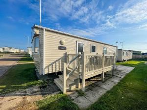 a mobile home with a porch and a deck at Lovely 6 Berth Caravan For Hire In Norfolk, By A Beautiful Beach! Ref 50030j in Great Yarmouth