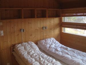 a room with a bed in a wooden wall at Svarthamar - cabin with amazing view in Al