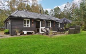 a small black house with a table and an umbrella at Gorgeous Home In Hadsund With Wifi in Hadsund