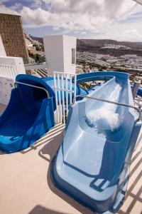 a blue slide on top of a roof at Servatur Puerto Azul in Puerto Rico de Gran Canaria