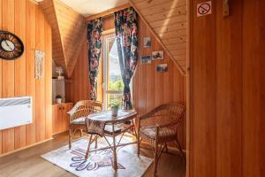 a dining room with a table and chairs and a window at ZAKOHOME Dom Banysiówka in Dzianisz +24 photos