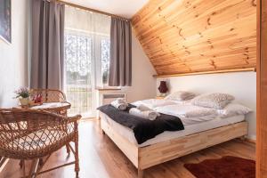 a bedroom with a bed with a wooden ceiling at ZAKOHOME Dom Banysiówka in Dzianisz