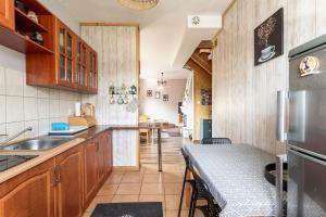 a kitchen with wooden cabinets and a table with a counter top at ZAKOHOME Dom Banysiówka in Dzianisz