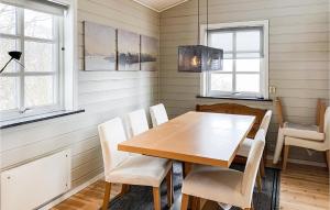 a dining room with a wooden table and chairs at Nice Home In Midsund With Kitchen in Midsund
