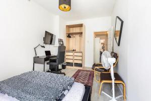 a bedroom with a bed and a desk with a computer at Chambres en appartements partagés in Liège