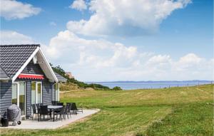 KnebelにあるStunning Home In Ebeltoft With 3 Bedrooms, Sauna And Wifiの小さな家(テーブル、椅子付)