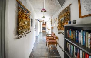un couloir avec une étagère, des chaises et des livres dans l'établissement 3 Bedroom Gorgeous Home In Anholt, à Anholt