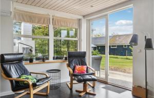 twee stoelen in een woonkamer met ramen bij Nice Home In Vggerlse With Wifi in Bøtø By
