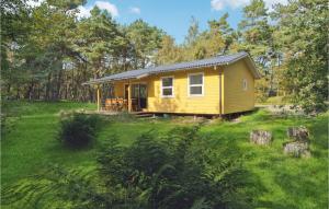 a yellow tiny house in the middle of a field at Awesome Home In Aakirkeby With 3 Bedrooms And Wifi in Vester Sømarken