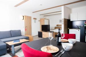 Apartament obejmuje kuchnię oraz salon ze stołem i czerwonymi krzesłami. w obiekcie Himmelsglück w mieście Lam