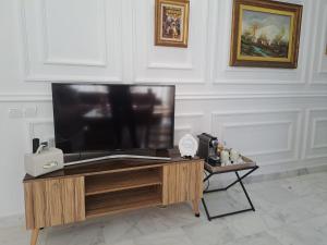 a flat screen tv sitting on top of a wooden table at Studio Casablanca aéroport nouaceur in Nouaceur