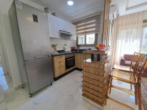 a kitchen with a stainless steel refrigerator and wooden cabinets at Studio Casablanca aéroport nouaceur in Nouaceur