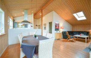 エーベルトフトにあるAmazing Home In Ebeltoft With 4 Bedrooms, Sauna And Wifiのダイニングルーム、リビングルーム(テーブル、椅子付)