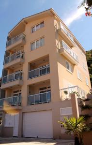 a tall apartment building with two garages at Apartments Lavanda in Budva