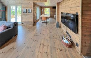 a living room with a large television and wooden walls at Beautiful Home In Eggedal With 4 Bedrooms in Eggedal