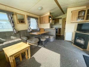 Great Clacton的住宿－Brilliant 10 Berth Caravan At Valley Farm Holiday Park, Essex Ref 46443v，客厅配有沙发和大篷车内的壁炉