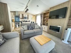 een woonkamer met 2 banken en een tv bij Beautiful Caravan With Decking At Carlton Meres Holiday Park, Suffolk Ref 60001m in Saxmundham