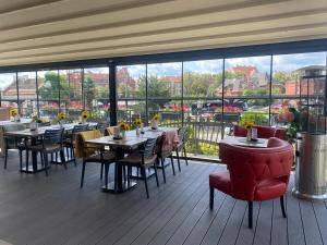 a restaurant with tables and chairs and a large window at Hotel Przystanek Torun in Toruń