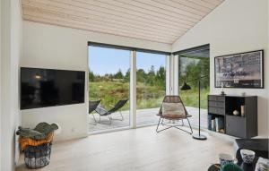 a living room with a large tv and sliding glass doors at Cozy Home In Fjerritslev With Kitchen in Slettestrand