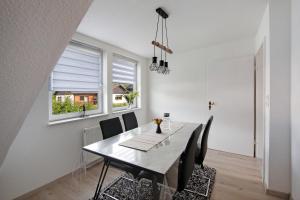 a dining room with a table and chairs and a window at Ferienwohnung zur Nordhelle in Herscheid