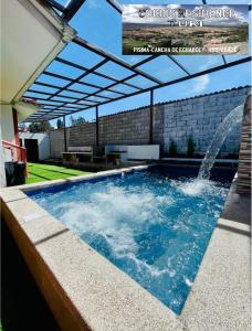 a swimming pool with a pergola and a fountain at Cocios Residence. A Magical Place in Cuenca