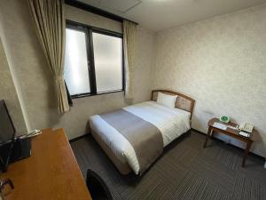 a hotel room with a bed and a window at Shinmatsudo Station Hotel in Matsudo