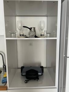 a cabinet with two wine glasses and a black stool at New Furnished Flat Central Location Free WIFI AC in Esenyurt