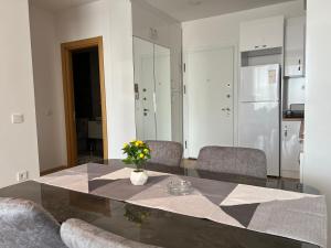 a dining room table with chairs and a vase of flowers at New Furnished Flat Central Location Free WIFI AC in Esenyurt