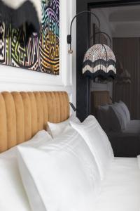 AS Boutique Hotel, superior في ليوبليانا: غرفة نوم بسرير ودهان ومصباح