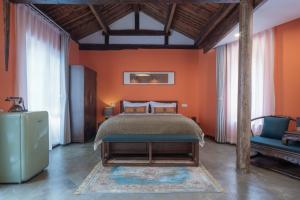 a bedroom with orange walls and a bed and a chair at Beijing Unified Courtyard Hotel in Beijing