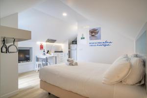 a white bedroom with a bed and a kitchen at Pero in Blue House in Jardim do Mar