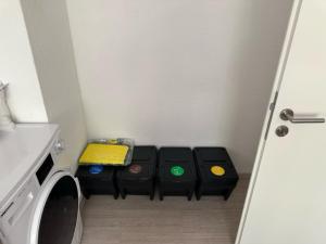 a small room with a washing machine and three bins at L8 Street - Leimen - Basement floor in Leimen