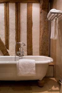 y baño con bañera blanca y paredes de madera. en Golf de Rebetz- Domaine de Rebetz, en Chaumont-en-Vexin