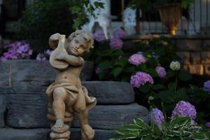 Una estatua de un niño parado en un jardín en Maxwell Mansion Hotel, en Lake Geneva