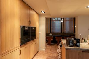 a kitchen with wooden cabinets and a dining room at Newly renovated luxurious 200 SQM loft in city centre in Amsterdam