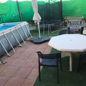 a patio with a table and chairs and a pool at סוויטות עין השמש eye sun in Arad